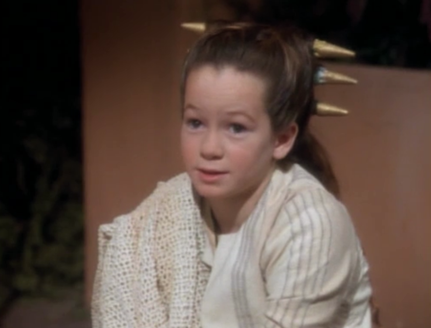 Young Noley Thornton as Taya wearing an off-white knitted shirt in a scene from Star Trek: Deep Space Nine Rewatch: “Shadowplay”.